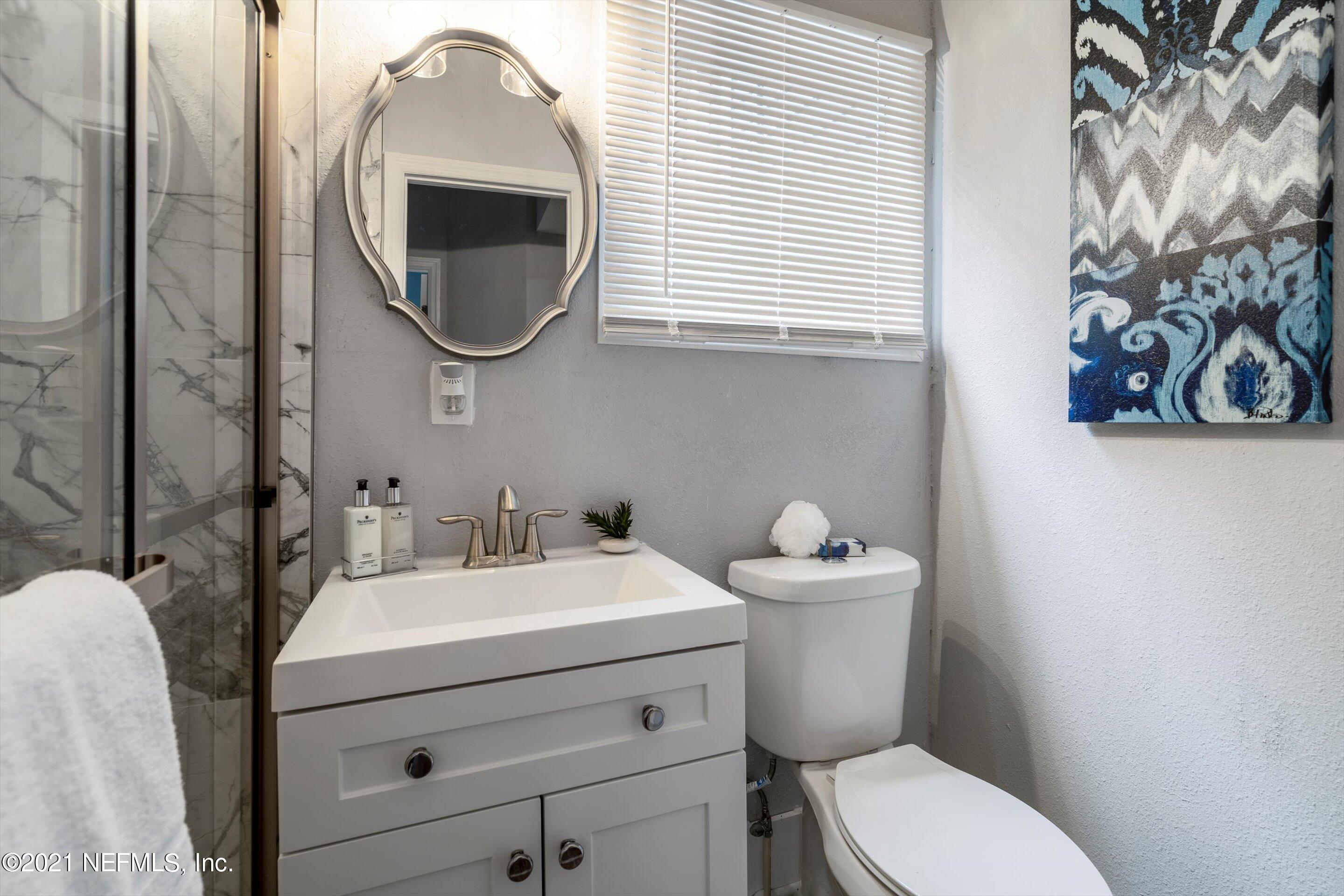 310 West 10th Street Jacksonville, FL 32206 - Photo 22 of 34 a bathroom with a toilet sink and mirror