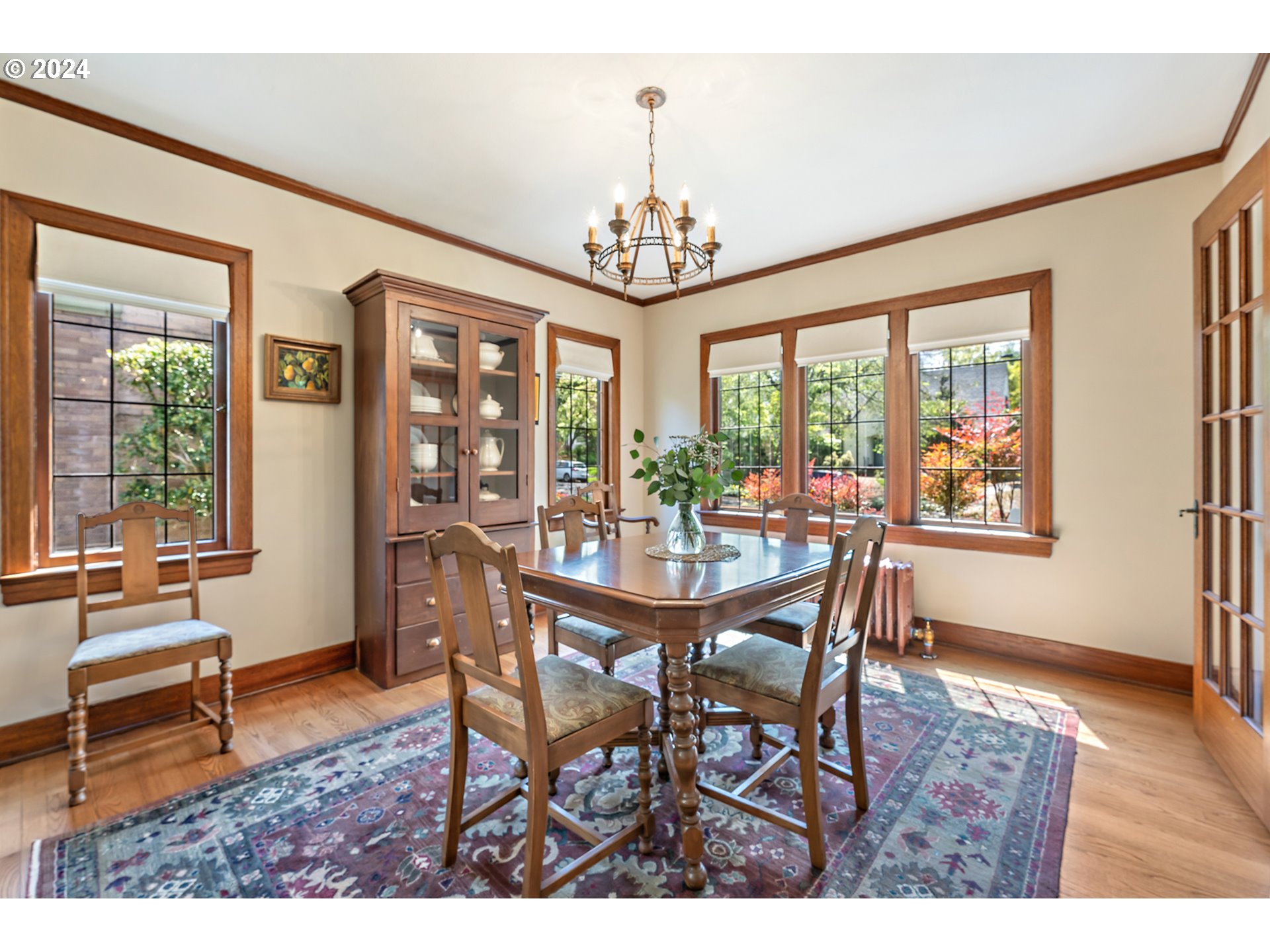 3433 Southeast Henry Street Portland, OR 97202 - Photo 11 of 48 a dining room with wooden floor a chandelier a wooden table and chairs