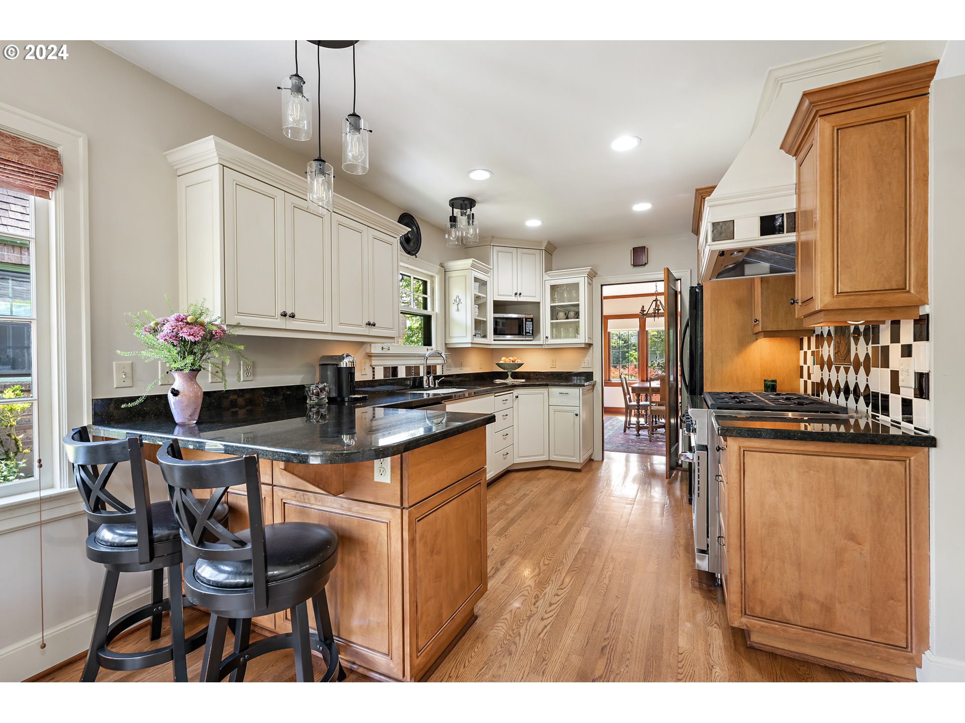 3433 Southeast Henry Street Portland, OR 97202 - Photo 15 of 48 a kitchen with stainless steel appliances kitchen island granite countertop a table chairs and a refrigerator