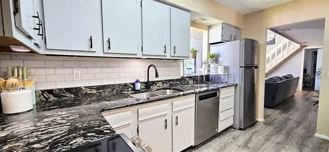 a kitchen with stainless steel appliances granite countertop a stove and a sink