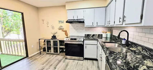 a kitchen with stainless steel appliances granite countertop a stove a sink and a refrigerator