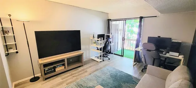 a living room with furniture a wooden floor and a large window