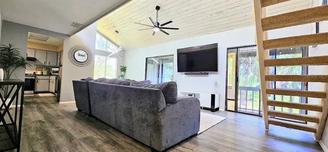 a living room with furniture a fireplace and a large window