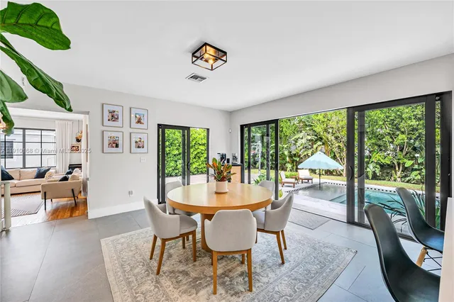a dining room with wooden floor a chandelier a glass table and chairs