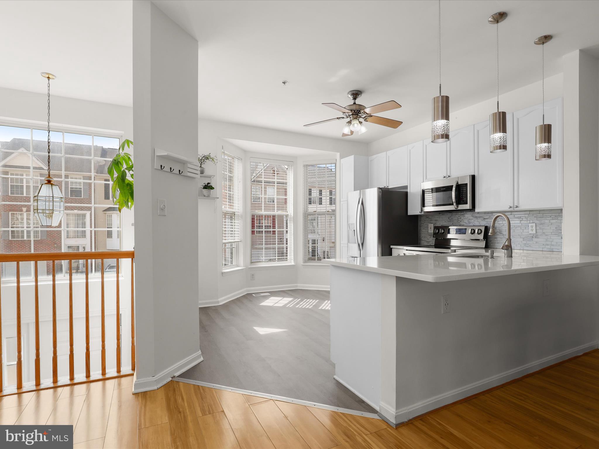 174 Harpers Way Frederick, MD 21702 - Photo 6 of 56 a kitchen with stainless steel appliances granite countertop a refrigerator a sink dishwasher a stove and a dining table with wooden floor