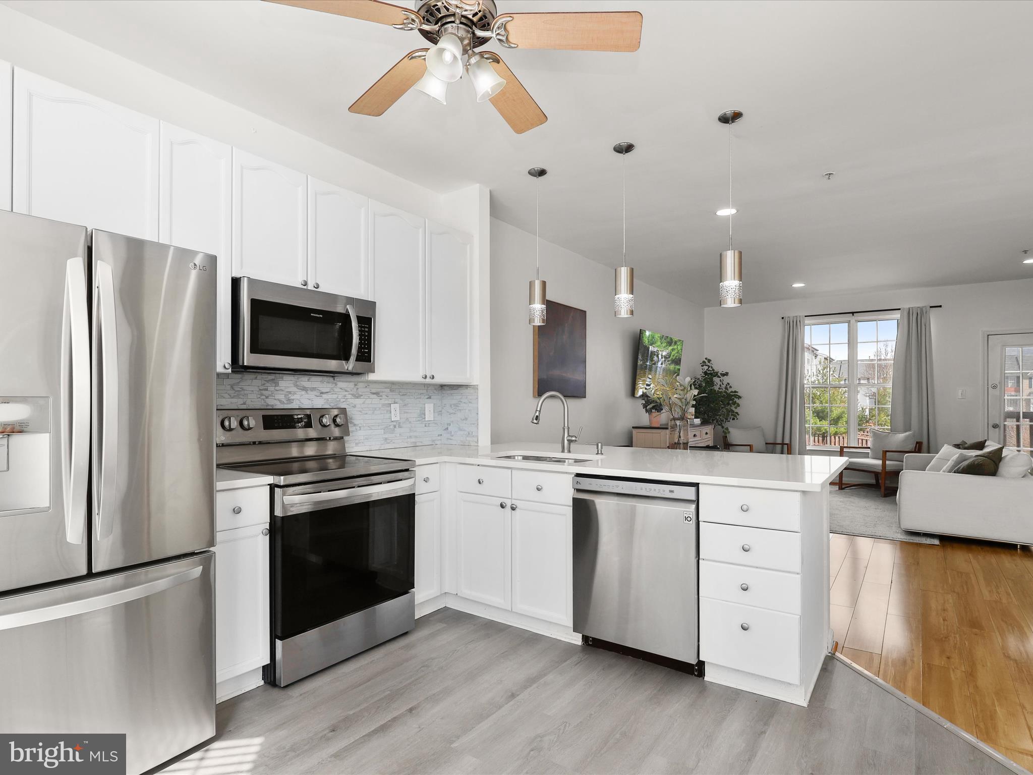 174 Harpers Way Frederick, MD 21702 - Photo 8 of 56 a kitchen with stainless steel appliances granite countertop a stove top oven a sink dishwasher a refrigerator and a dining table with wooden floor