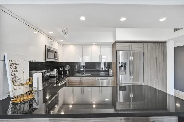 a kitchen with stainless steel appliances granite countertop a refrigerator and a stove top oven