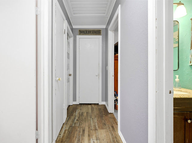 30063 South 4300th Road Stigler, OK 74462 - Photo 19 of 58 Hallway featuring wood-finish flooring, light gray walls, white trim, and a white paneled ceiling