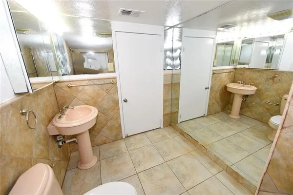 a bathroom with a sink a toilet and shower