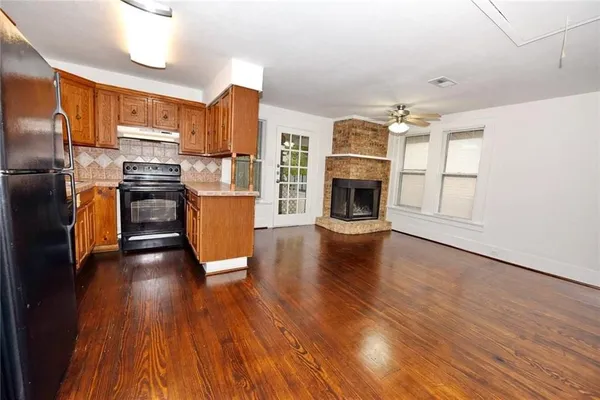 a kitchen with stainless steel appliances wooden floors and large window