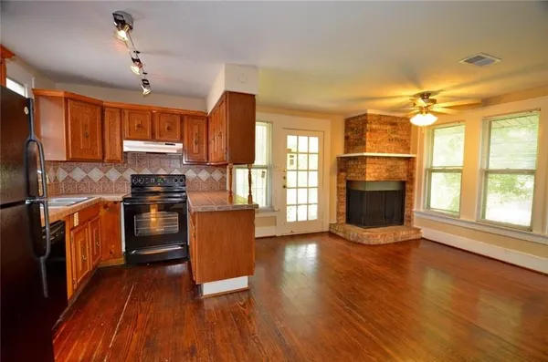 a kitchen with granite countertop a stove top oven a sink and a refrigerator