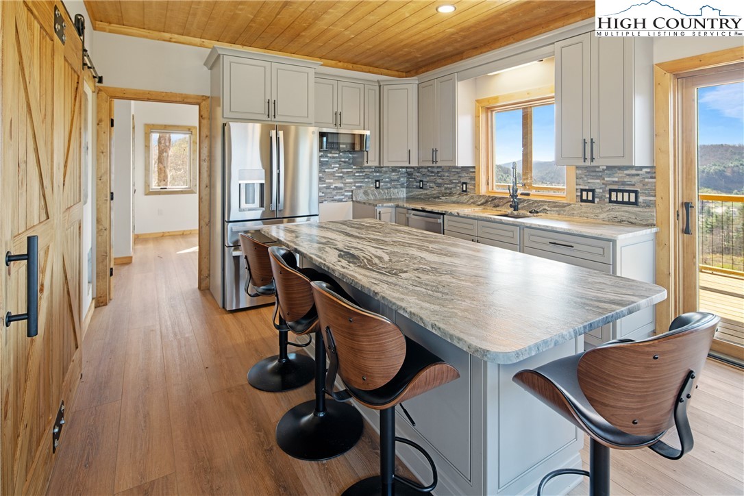 330 Maplewood Circle Boone, NC 28607 - Photo 4 of 44 a kitchen with stainless steel appliances granite countertop table chairs and wooden floors