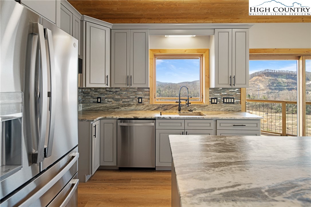 330 Maplewood Circle Boone, NC 28607 - Photo 9 of 44 a kitchen with stainless steel appliances granite countertop a refrigerator a stove and a sink with wooden floor