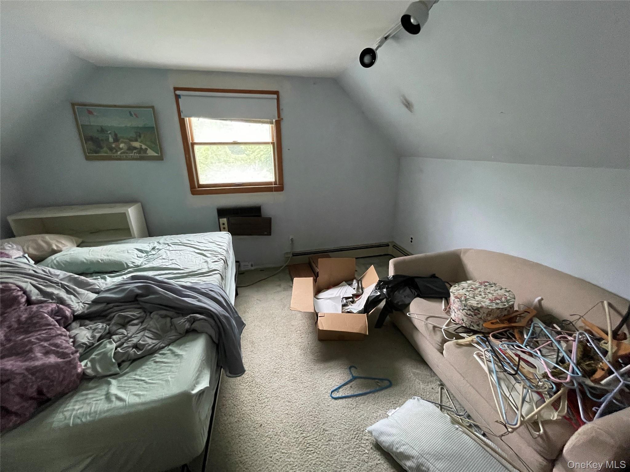 2043 Paddock Road Seaford, NY 11783 - Photo 13 of 25 a bedroom with bed couch and window