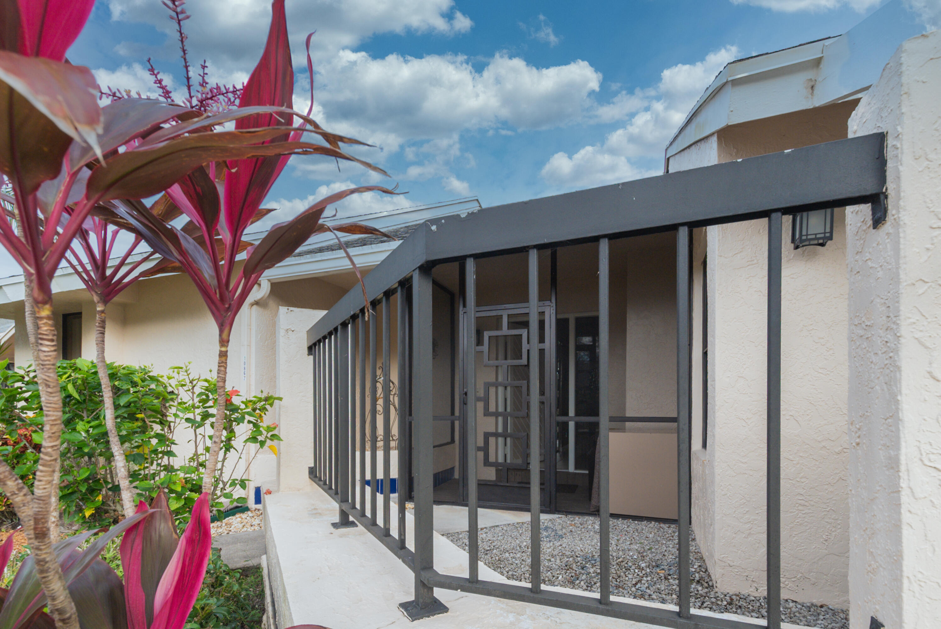 10867 Waterberry Court Boca Raton, FL 33498 - Photo 2 of 30 a view of a house with a small yard and potted plants
