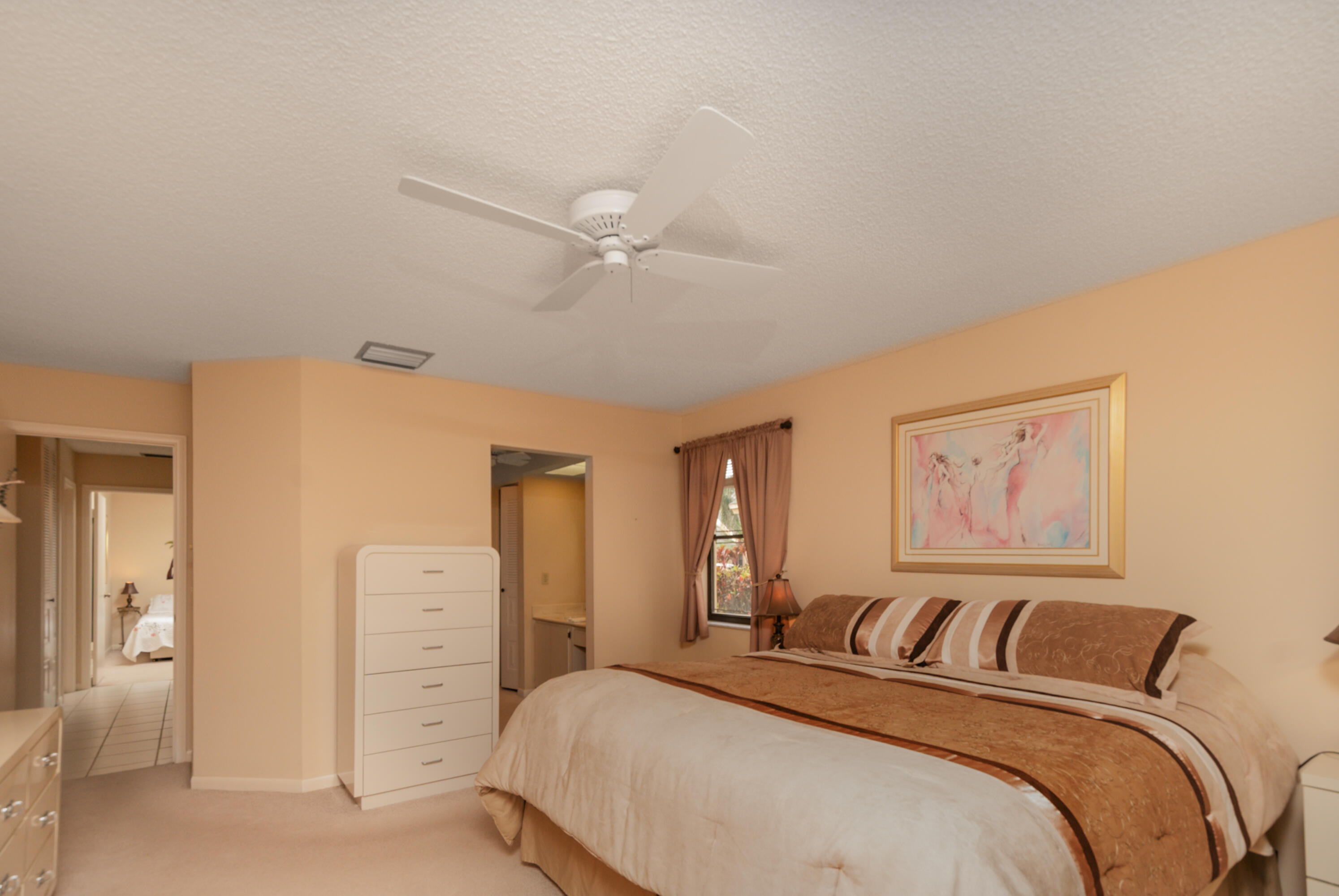 10867 Waterberry Court Boca Raton, FL 33498 - Photo 6 of 30 a bedroom with a bed and a chandelier