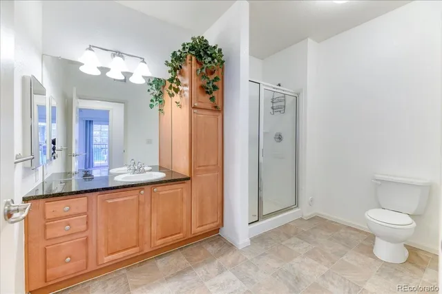 a bathroom with a granite countertop sink a toilet and a mirror