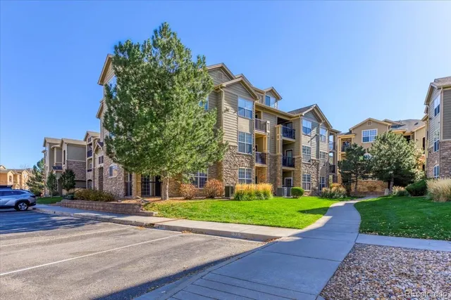 a view of a big building with a big yard and large trees