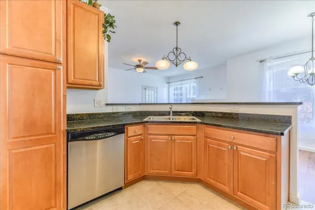 a kitchen with stainless steel appliances granite countertop a sink a stove and a refrigerator