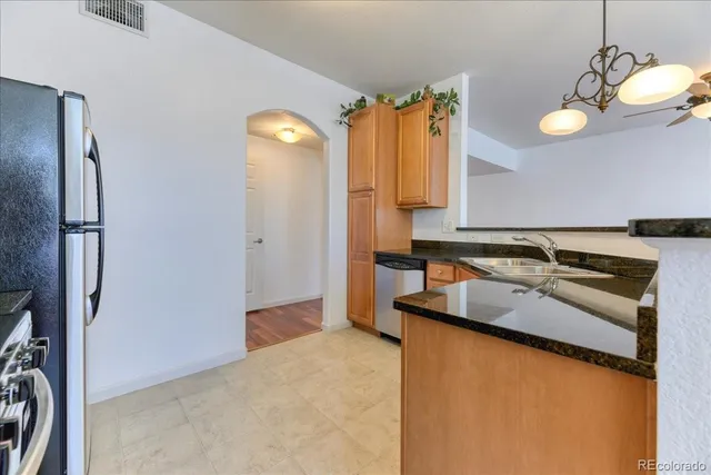 a kitchen with stainless steel appliances granite countertop a sink and a refrigerator