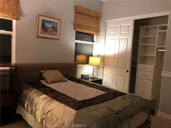 a bedroom with a bed and painting on the wall