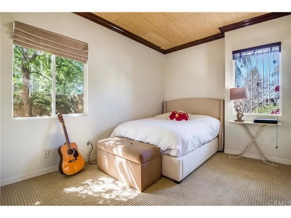 a bed sitting in a bedroom next to a window