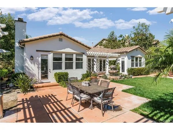 a view of a house with backyard sitting area and garden