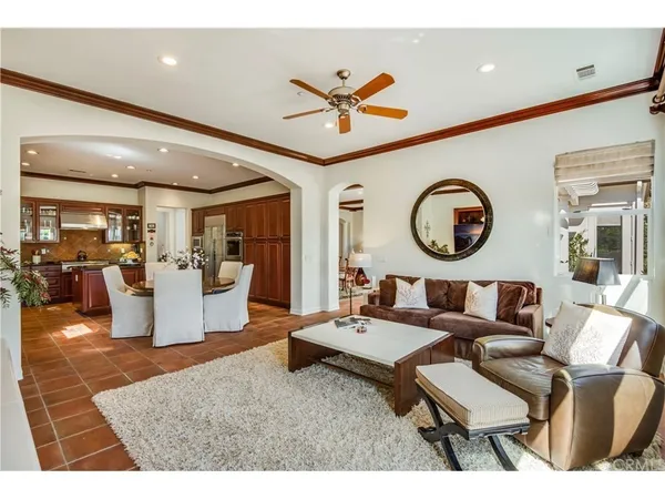 a living room with couches a dining table and kitchen view