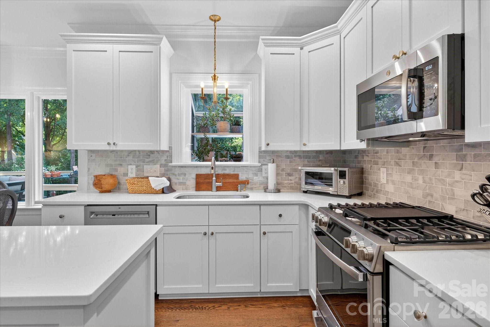 1302 Foxfield Road Waxhaw, NC 28173 - Photo 4 of 6 a kitchen with stainless steel appliances white cabinets a sink a stove a microwave a counter top space and cabinets