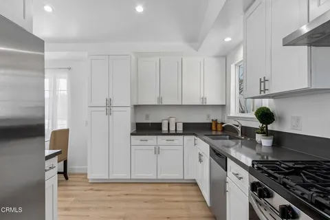 a kitchen with stainless steel appliances granite countertop a stove a sink and a refrigerator