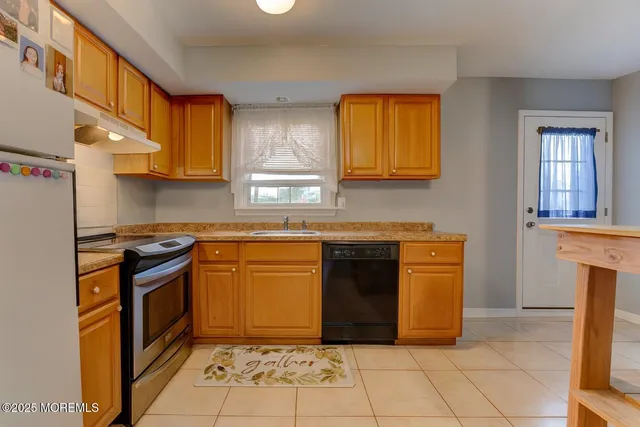 a kitchen with granite countertop a stove top oven and cabinets