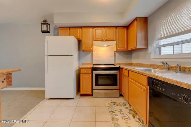 a kitchen with a stove a sink and a refrigerator