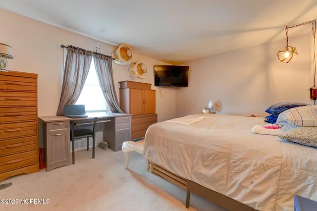 a bedroom with a bed and a flat tv screen on wall