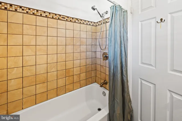 a view of a room with wooden floor and a ceiling fan