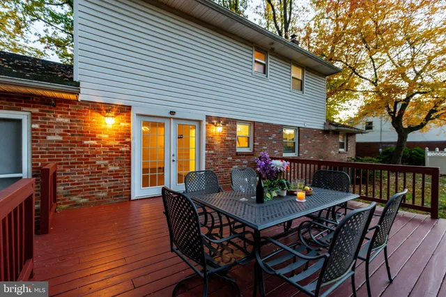 a view of a roof deck with table and chairs with wooden floor and fence