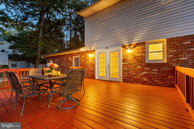 a view of a roof deck with table and chairs with wooden floor and fence