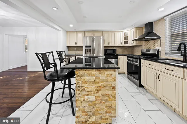 a kitchen with stainless steel appliances granite countertop a refrigerator and a stove top oven