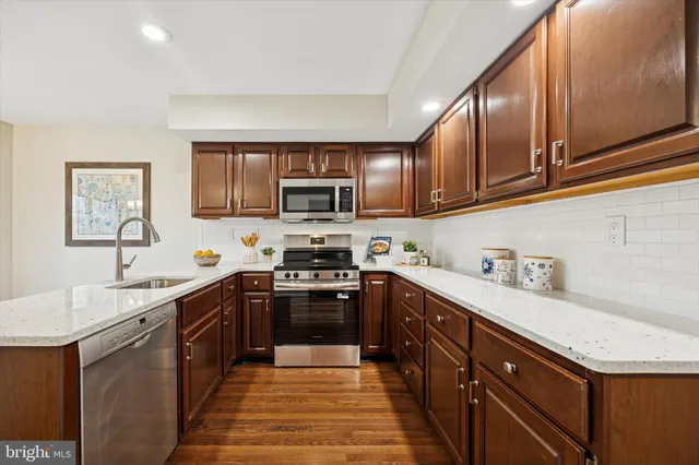 a kitchen with stainless steel appliances granite countertop a sink stove microwave and cabinets