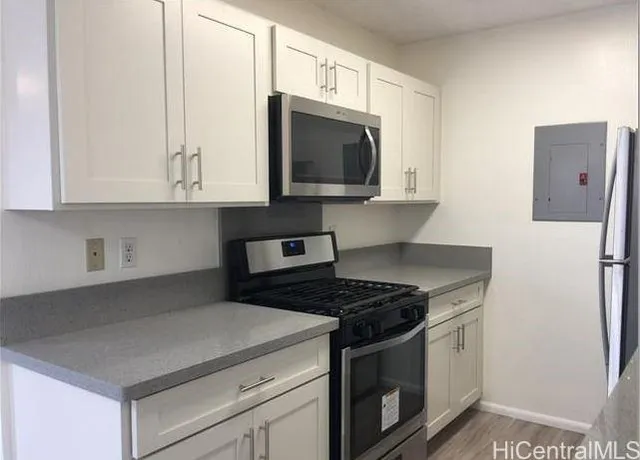 a kitchen with stainless steel appliances granite countertop a stove a microwave and a refrigerator