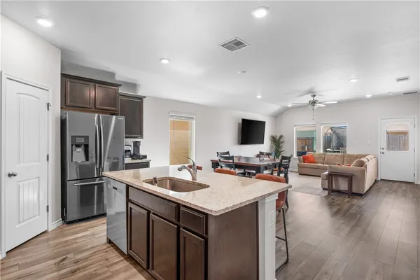 a kitchen with a refrigerator a sink dishwasher stove and oven with wooden floor