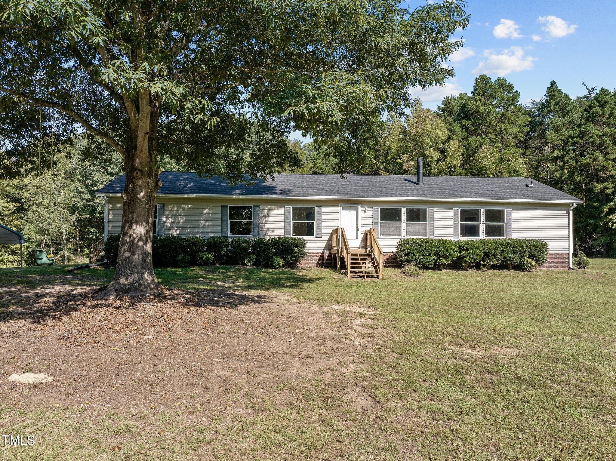 89 Munday Road Roxboro, NC 27574 - Photo 30 of 46 a front view of a house with a yard and trees