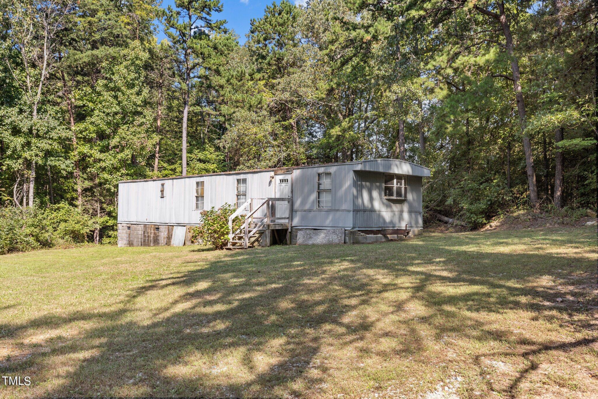 89 Munday Road Roxboro, NC 27574 - Photo 36 of 46 a view of a house with a yard and large trees