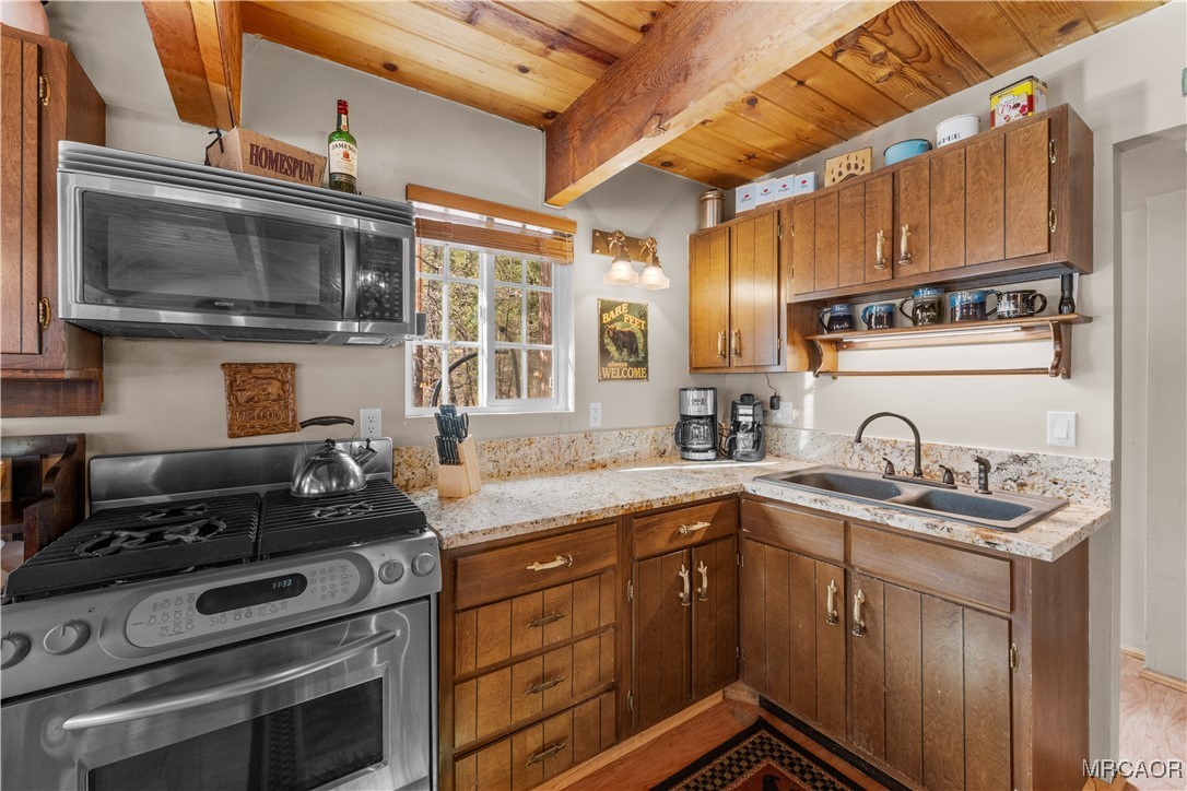 1289 Canyon Road Fawnskin, CA 92333 - Photo 6 of 23 a kitchen with stainless steel appliances granite countertop a stove microwave and sink