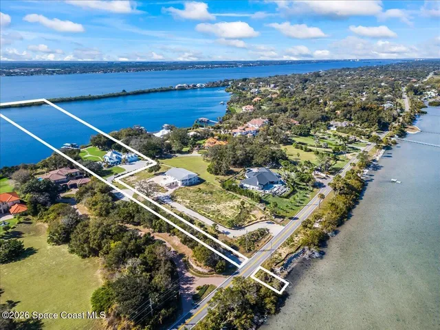a living room with furniture floor to ceiling window and a flat screen tv