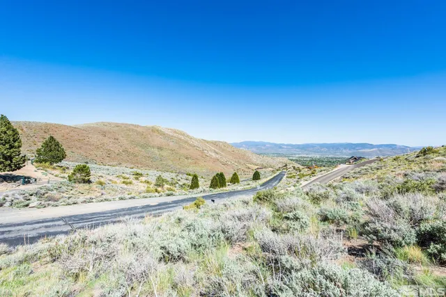 a view of mountain with a lake in the background