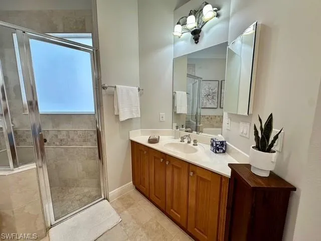 a bathroom with a double vanity sink a mirror and shower