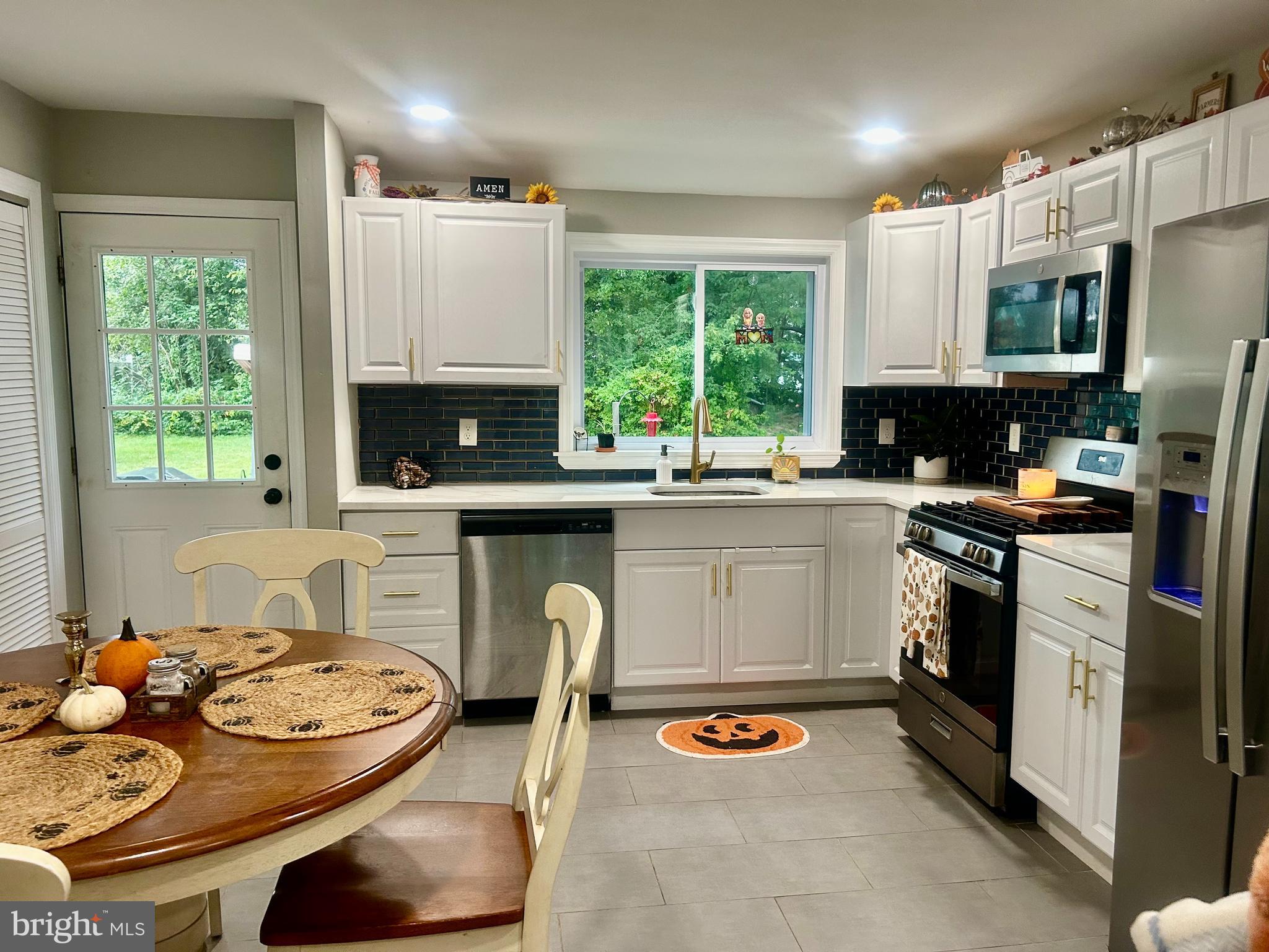 22 Bettlewood Road Marlton, NJ 08053 - Photo 5 of 15 a kitchen with a stove a sink dishwasher a dining table and chairs with wooden floor