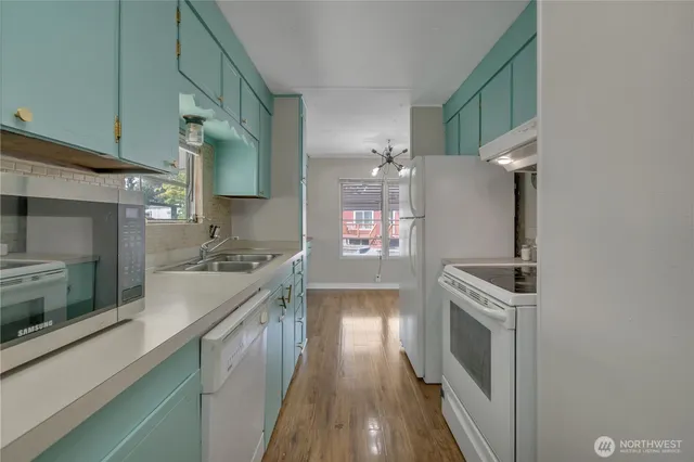 a kitchen with granite countertop a sink stove and refrigerator