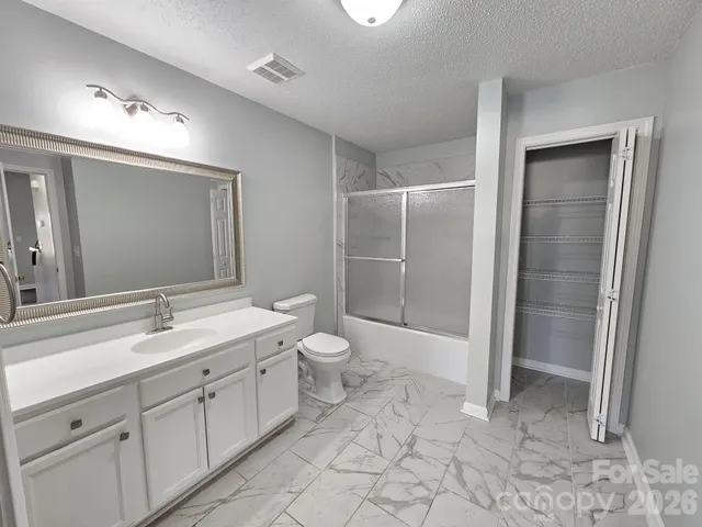 a spacious bathroom with a shower sink and mirror