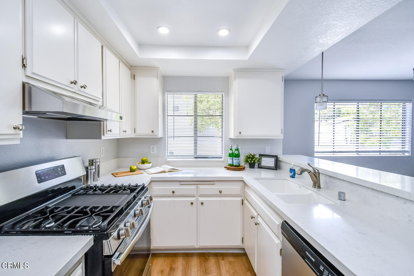 249 Alpine Street, Unit 53 Pasadena, CA 91106 - Photo 12 of 33 a kitchen with granite countertop a sink a window stainless steel appliances and cabinets